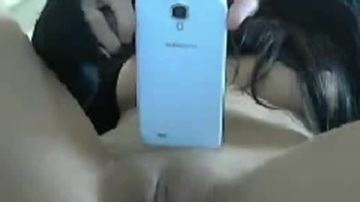 Brunette teen shows her smartphone and pussy